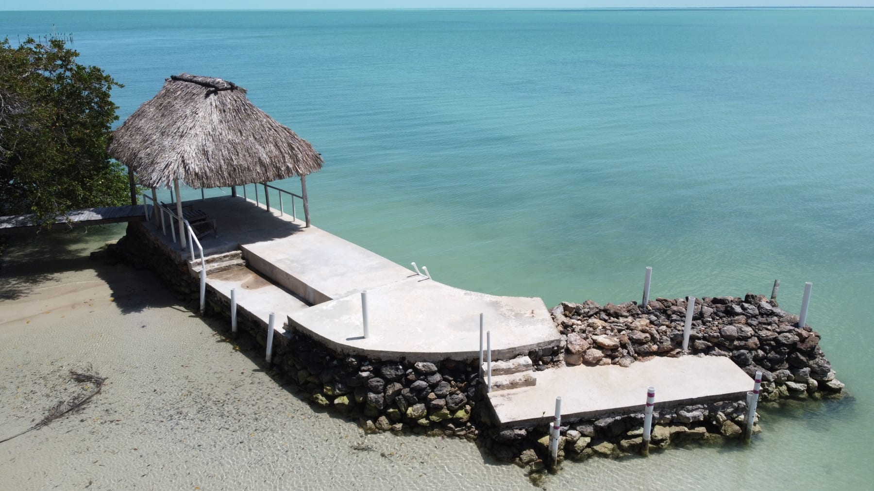 Palapa and pier over the turquoise water at 47 Consejo Beach Trail